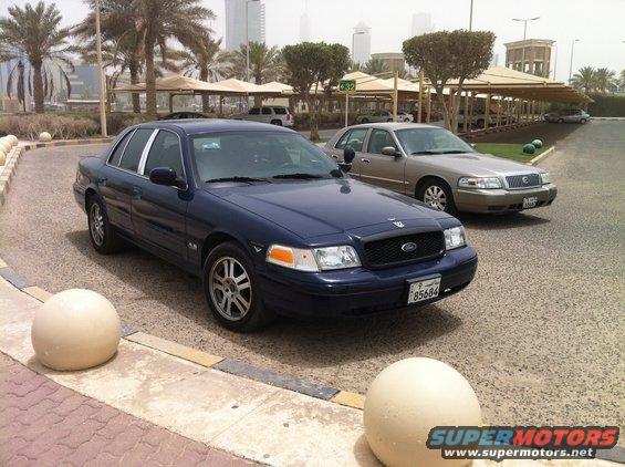 Blue 2007 Ford Crown Victoria parked on street with another car behind it
