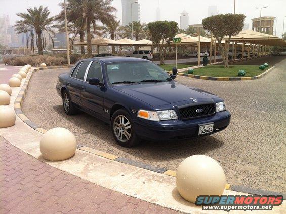 Dark blue 2007 Ford Crown Victoria parked on a street with large spherical bollards
