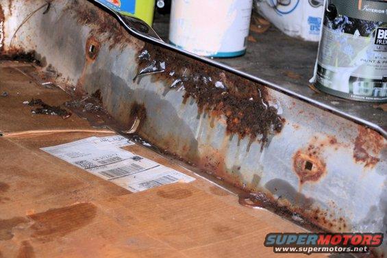Rusted metal part with water drips and shipping label