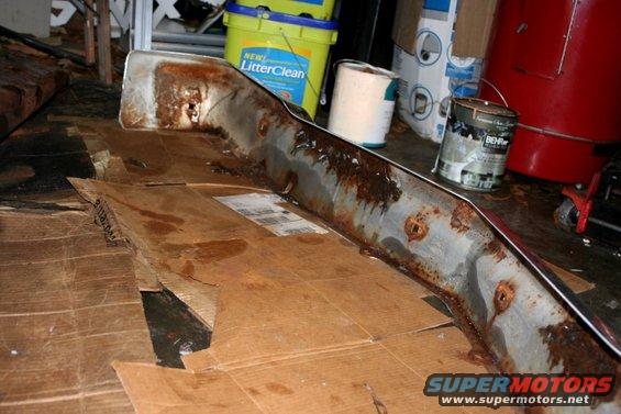 rusted chrome bumper piece on cardboard