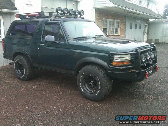 Dark green 1993 Ford Bronco with roof rack and off-road bumper