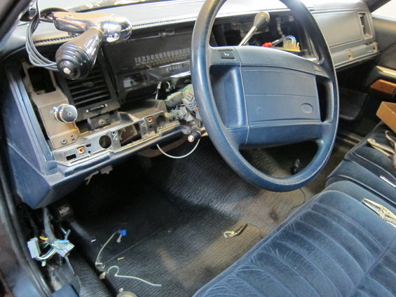 Interior view of a disassembled dashboard with blue velour seats