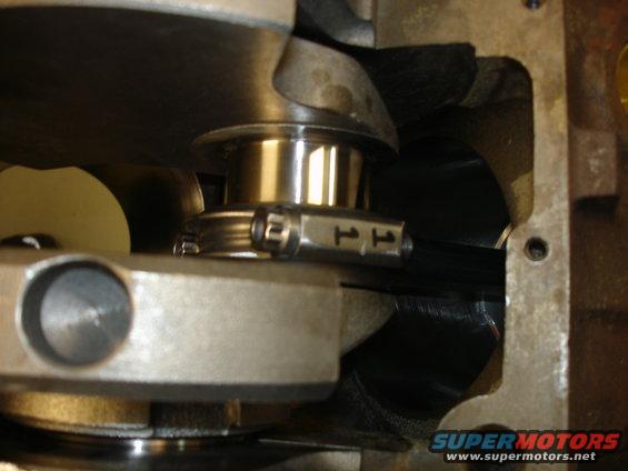 Close-up of engine crankshaft with connecting rod and bearing cap showing '11' markings