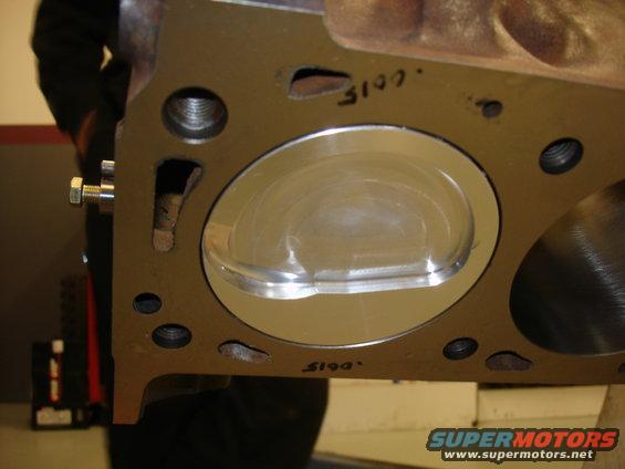 Engine cylinder head with a piston inside a cylinder bore, marked with handwritten numbers