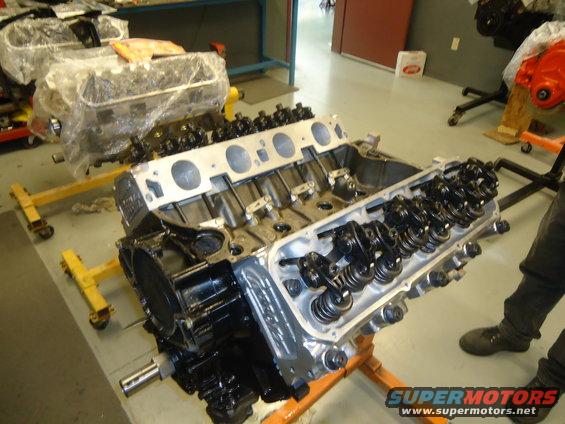 Engine on stand, another engine covered in plastic in background