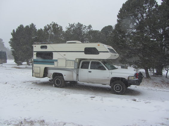 1997 Dodge 3500 pickup with camper shell parked in snow