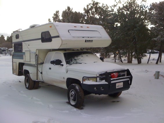 1997 Dodge 3500 pickup truck with a Lance camper shell, parked in the snow