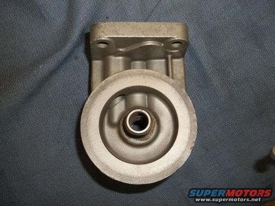 Metal oil filter housing with mounting holes and a central threaded opening