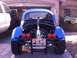 1970 Volkswagen Beetle - This modified Beetle features a prominent exhaust and custom rear bumper, parked next to a pickup truck.