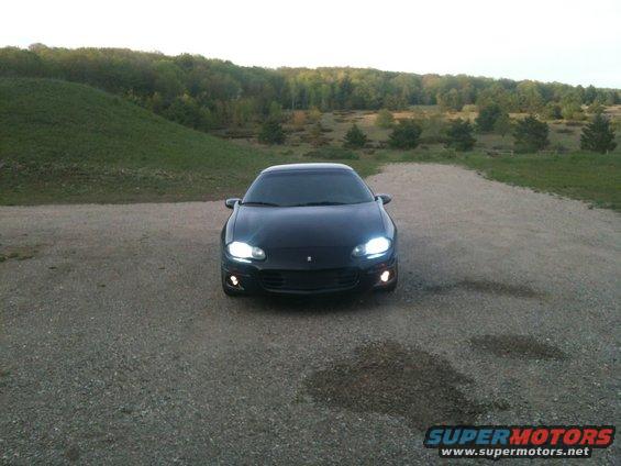 Black 1998 Chevrolet Camaro front view with headlights on