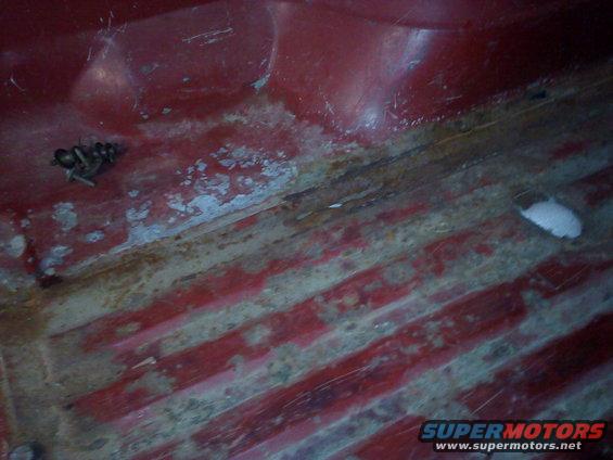 Red interior floor with rust and bolts visible