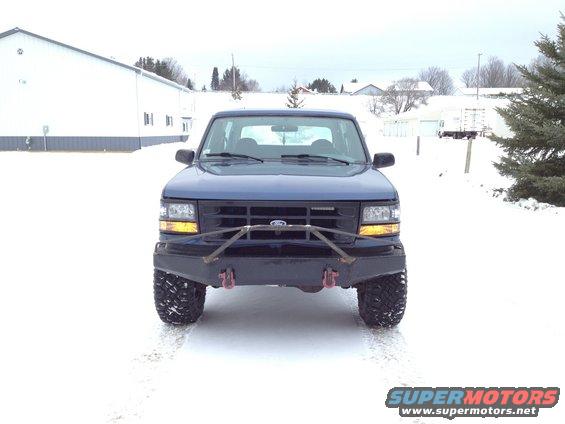 Blue 1996 Ford Bronco front view with aftermarket bumper and tires in snow