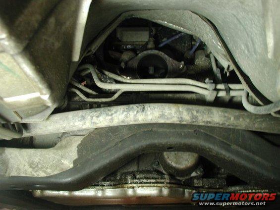 Underside of a vehicle showing exhaust components and oil pan