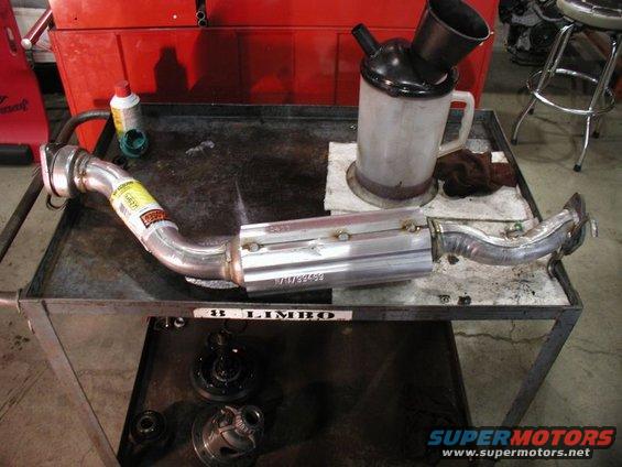 Exhaust catalytic converter on a workbench with a funnel and oil jug
