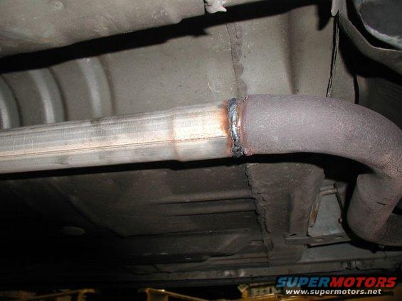 Close-up of a welded exhaust pipe section underneath a vehicle