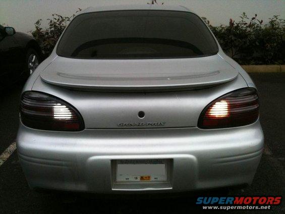 Silver 2002 Pontiac Grand Prix rear view with illuminated backup lights