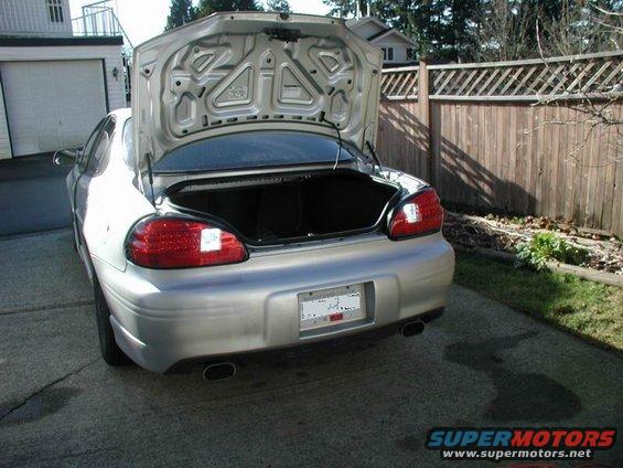 Silver 2002 Pontiac Grand Prix with trunk open, parked in a driveway