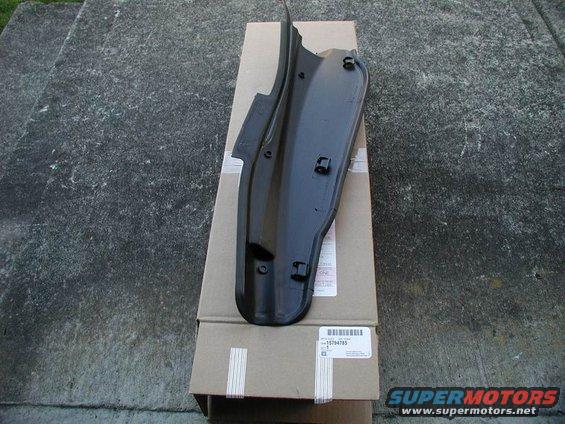 Black plastic car part with clips, sitting on cardboard boxes. Part number 15784785 visible