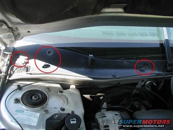 Windshield cowl area with red circles highlighting mounting points and a drain hole