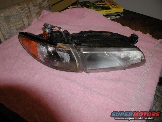Car headlight assembly with orange turn signal bulb visible