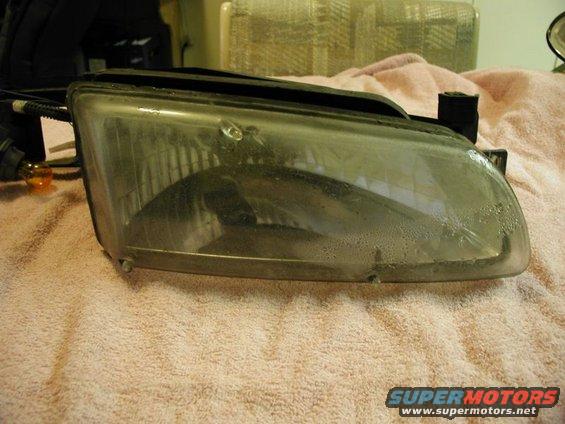 Headlight assembly with condensation inside, resting on a pink towel