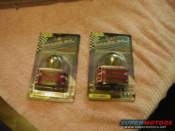 Two packaged 3157 amber light bulbs with "TITANIUM" branding