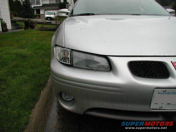 Silver sedan's front end, showing headlights, grille, and bumper. License plate reads 'Beautiful Br'