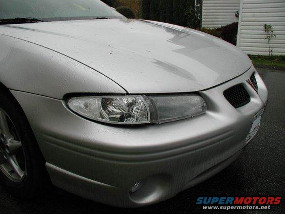 Silver 2002 Pontiac Grand Prix front end with clear corner headlights and a black grille