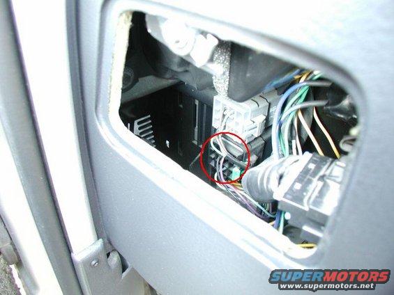 Interior wiring harness with red circle around a green connector