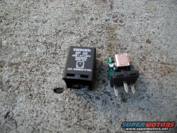 Two electronic components, one black Tridon EP 26 relay and a circuit board with a USB connector, lie on a textured concrete surface