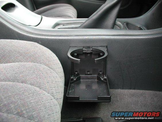 Folding cup holder in a 2002 Pontiac Grand Prix interior, next to a gray patterned seat