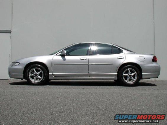Side view of a silver 2002 Pontiac Grand Prix parked against a wall