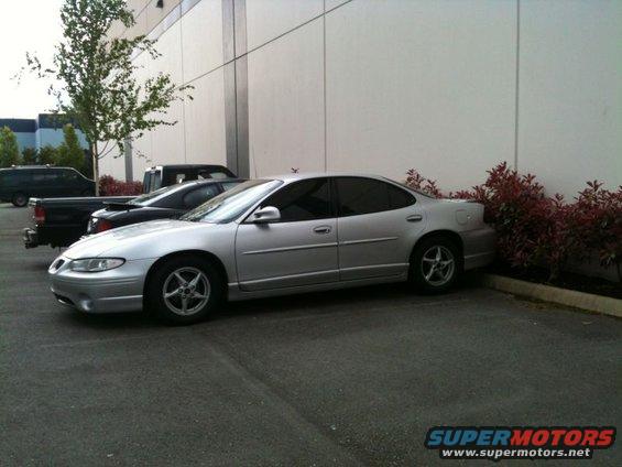Silver 2002 Pontiac Grand Prix sedan parked next to a building