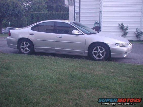 Silver 2002 Pontiac Grand Prix parked on grass next to a house