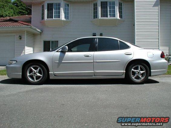 Silver 2002 Pontiac Grand Prix sedan, side view, lowered suspension, aftermarket wheels, parked in driveway