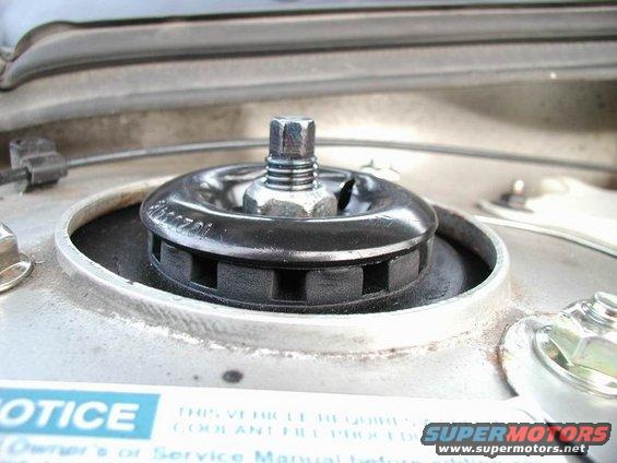 Close-up of a car's strut mount with a bolt and nut