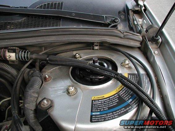 Engine bay with a sticker indicating R-134a refrigerant and General Motors Corporation