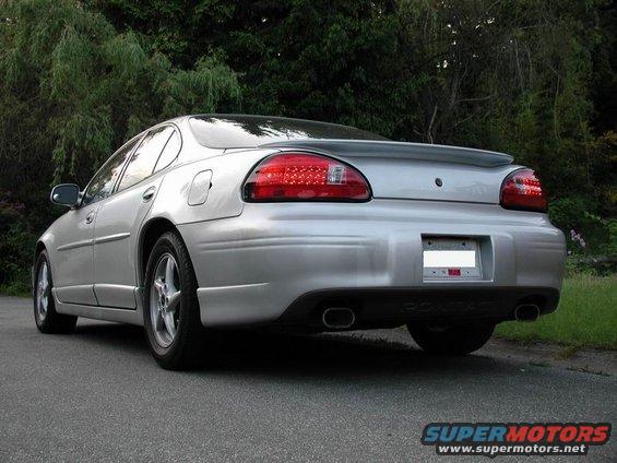 Rear view of a silver 2002 Pontiac Grand Prix with a spoiler and dual exhaust pipes