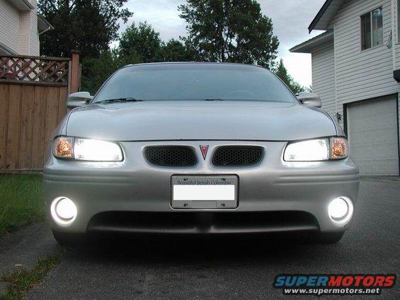 Front view of a silver 2002 Pontiac Grand Prix with headlights and fog lights on