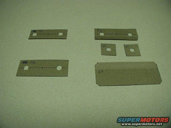 Cardboard templates with holes and handwritten labels like T2 and E3