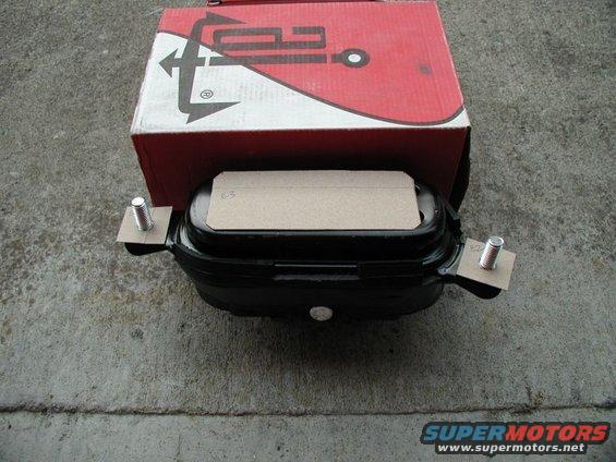 Black car part with bolts and a red box with logo