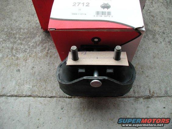 Engine mount part with two bolts and a piece of cardboard marked 'TZ'. Box in background has part number 2712