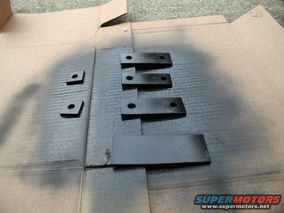 Black painted metal brackets and plates on cardboard