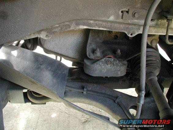 Close-up of a vehicle's engine mount and suspension parts, including a rubber isolator and CV boot