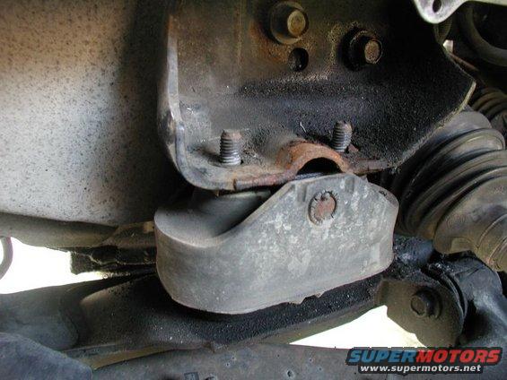Close-up of a vehicle's engine mount bracket and rubber isolator