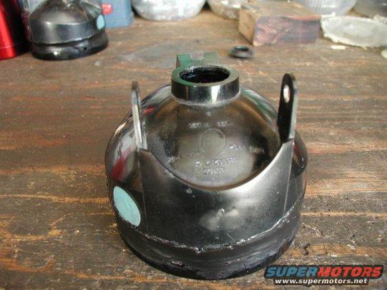 Metal automotive part with a circular opening and a green sticker