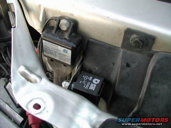 Close-up of a QM 40A 12VDC relay and a black control module with Chinese text, mounted in an engine bay