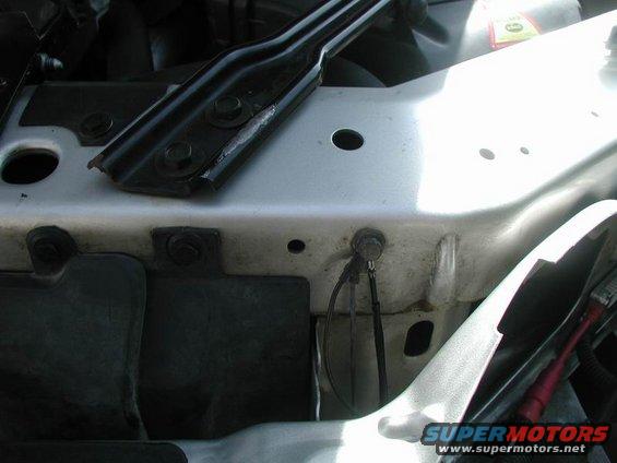 Close-up of car's engine bay showing metal brackets and wiring