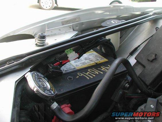 Engine bay showing battery, radiator cap, and wiring
