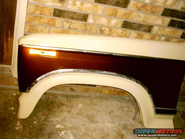 Two-tone fender, brown and cream, with amber turn signal and chrome trim